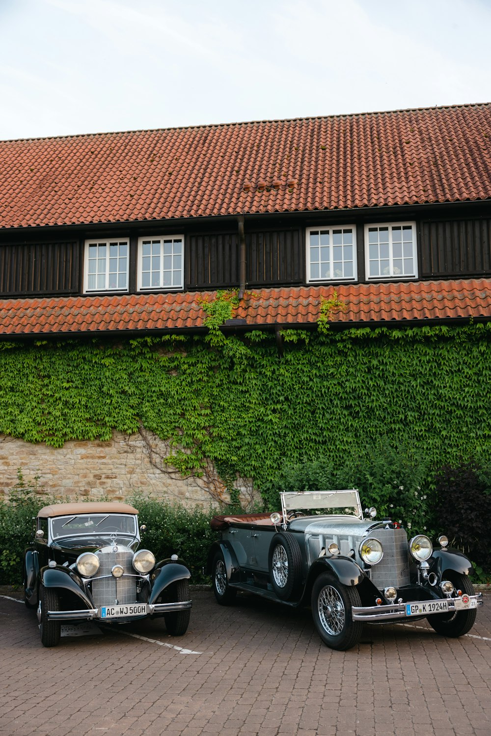 two antique cars parked in front of a building