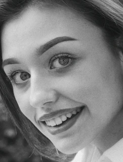 Elegant monochrome side profile showing refined dental alignment with a hint of warm lighting around the jawline.