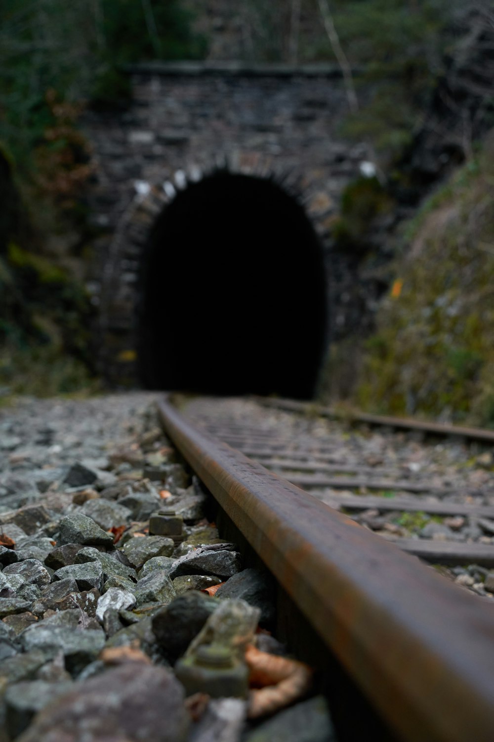a tunnel with rocks and a train track