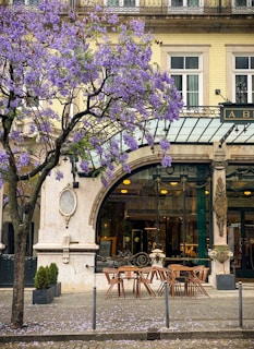 a building with a large arched doorway and tables and chairs outside