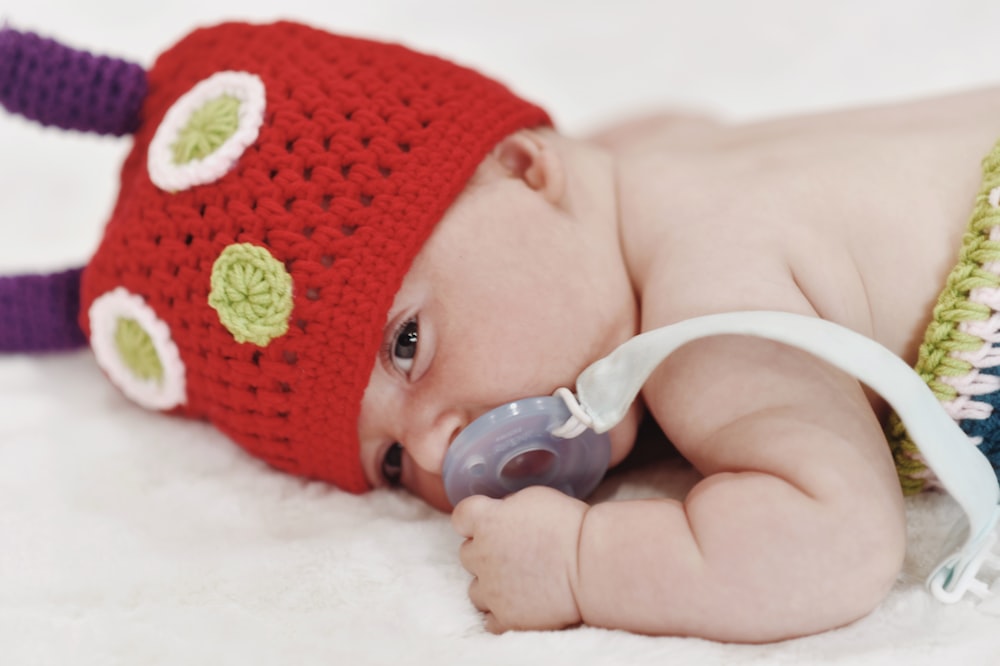 a baby with a red hat