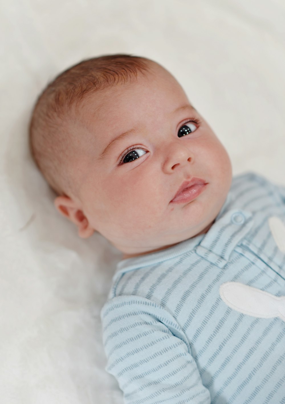 a baby lying on a blanket