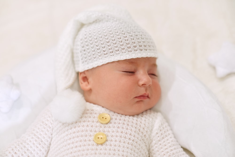 a baby sleeping in a white blanket