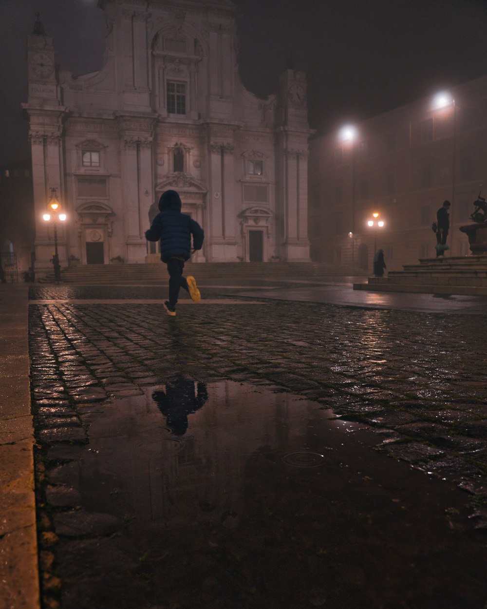 a person walking in a wet street
