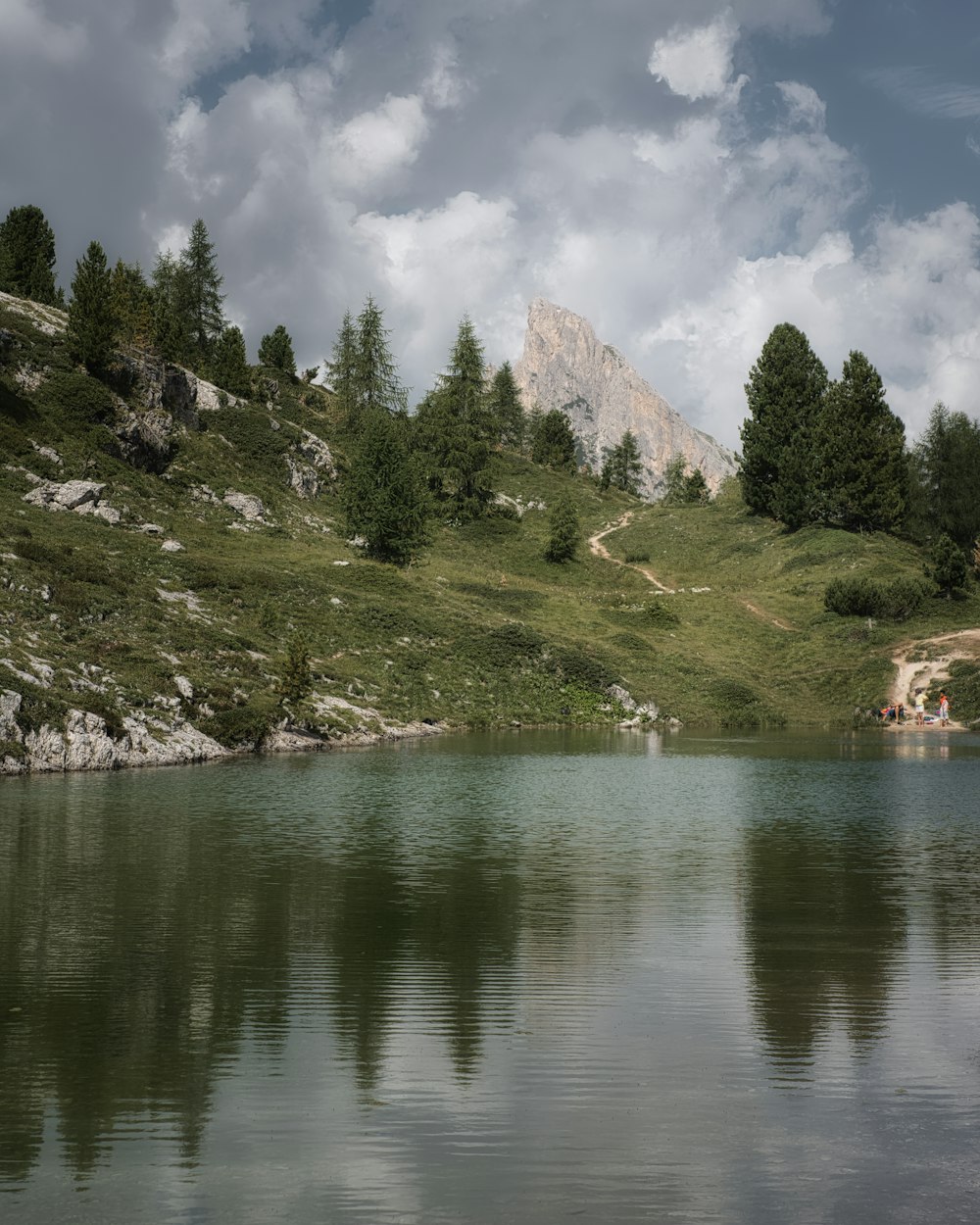 A lake with trees and mountains in the background photo – Free Italy ...