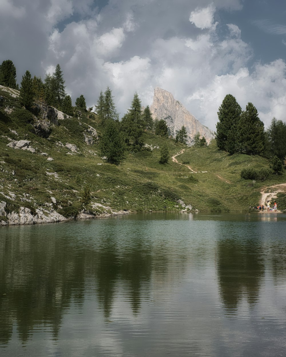 a lake with trees and mountains in the background