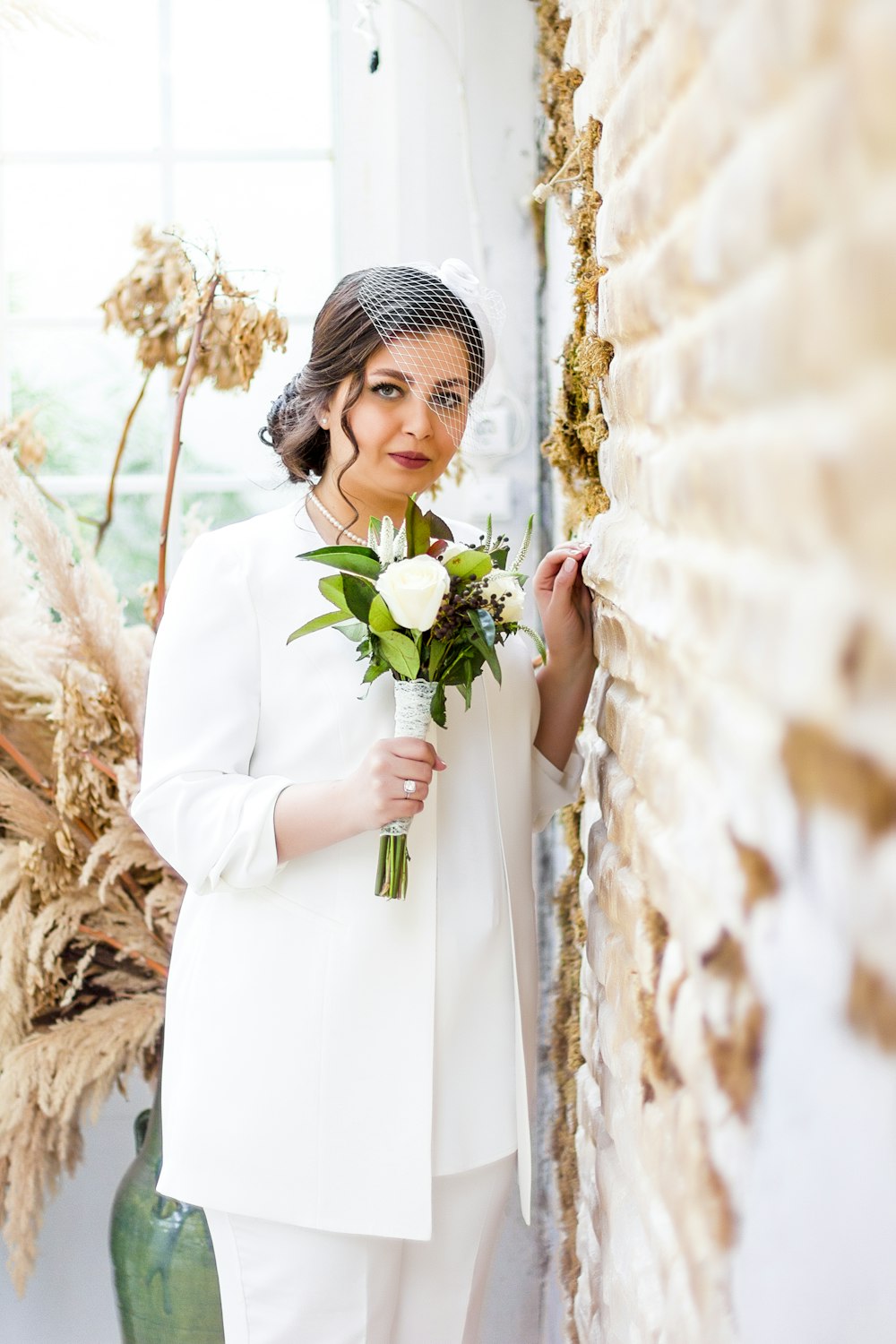 a person in a white dress holding a bouquet of flowers