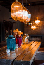 a chandelier over a table with vases of flowers