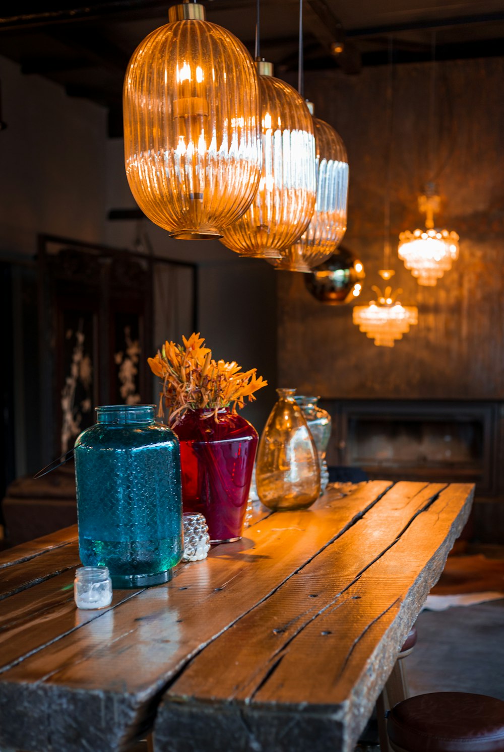 a chandelier over a table with vases of flowers