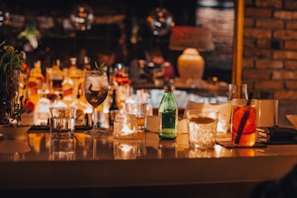 A cozy bar counter with colorful cocktails and warm lighting.