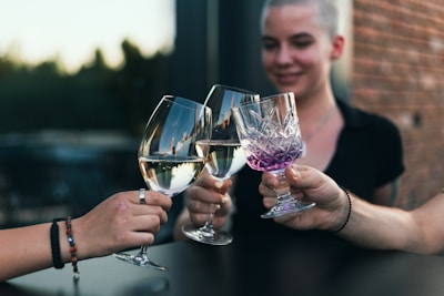 a person holding a couple of wine glasses