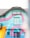 A building with vibrant, colorful street art features a prominent sign with the word 'SEDE'. The facade is painted in bright blue, pink, and orange with abstract, flowing patterns. There are windows and string lights hanging across the front.