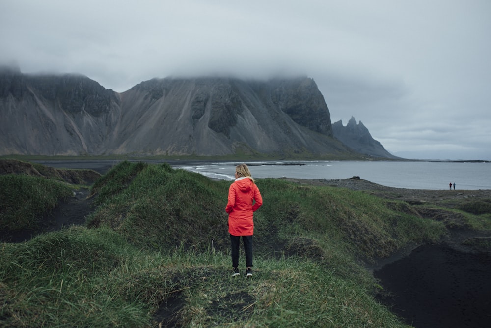 a person standing on a hill overlooking a body of water