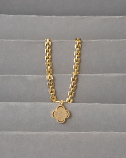 a gold chain on a grey surface