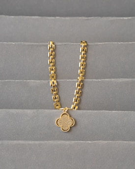 a gold chain on a grey surface