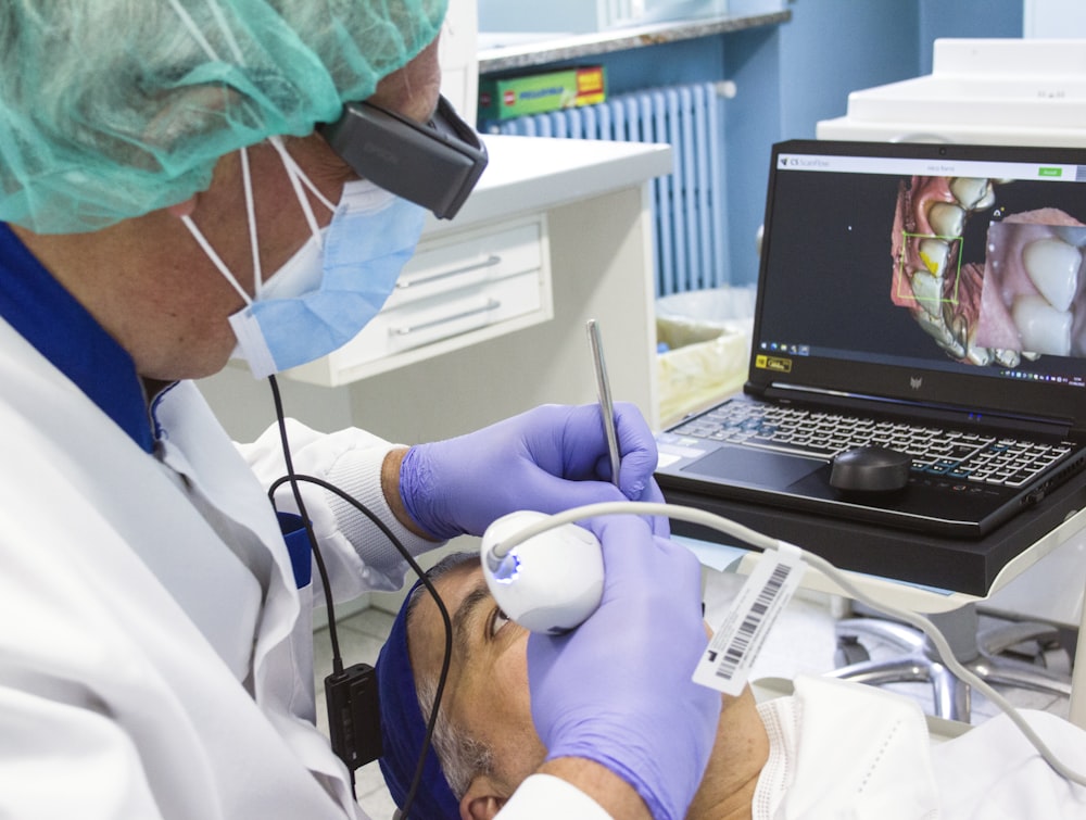 a person in a mask and gloves using a laptop