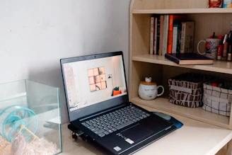 A warm, inviting workspace with a laptop open to a pet blog, surrounded by a cat, a bird in a cage, and a small aquarium.