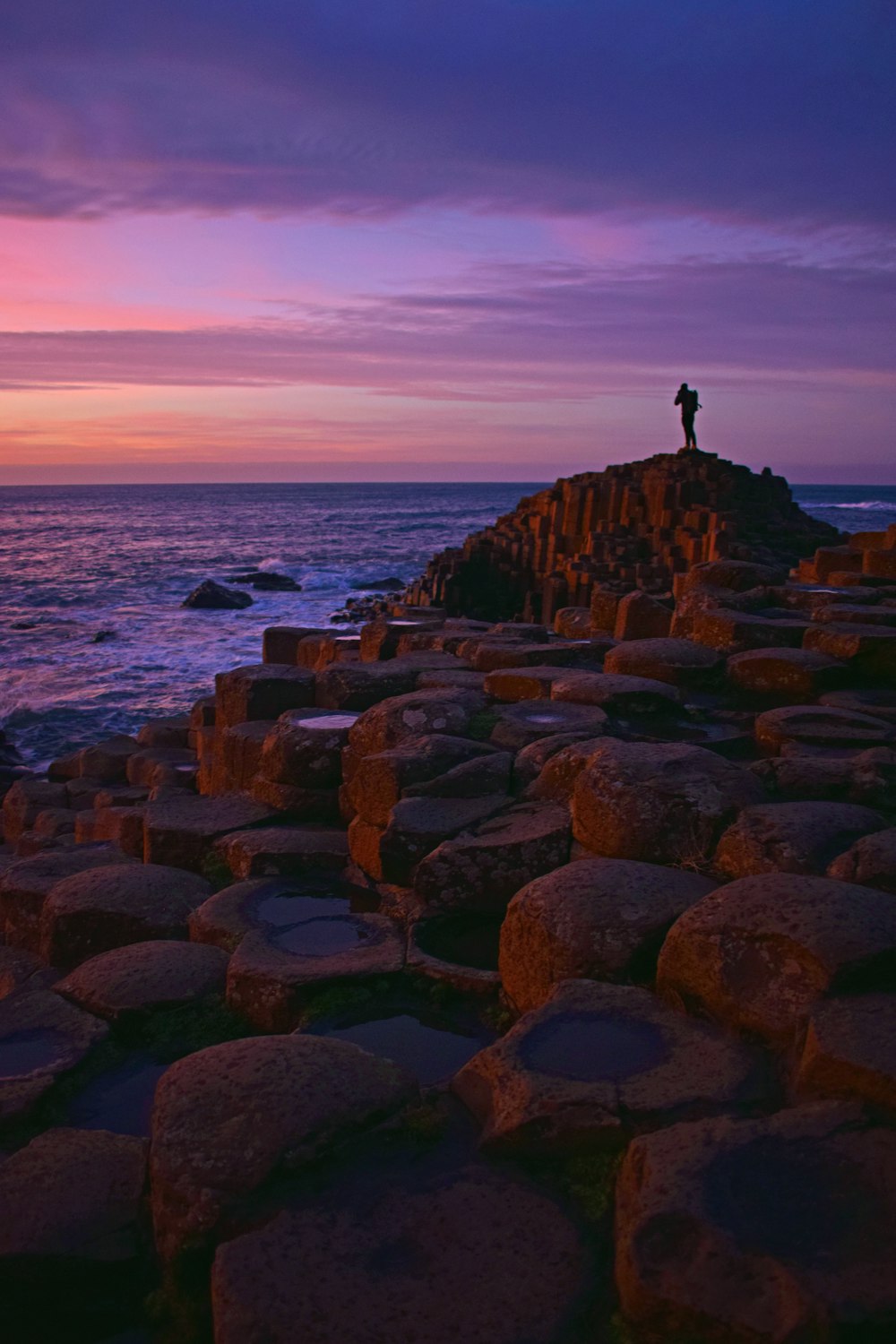 a person standing on a rocky beach