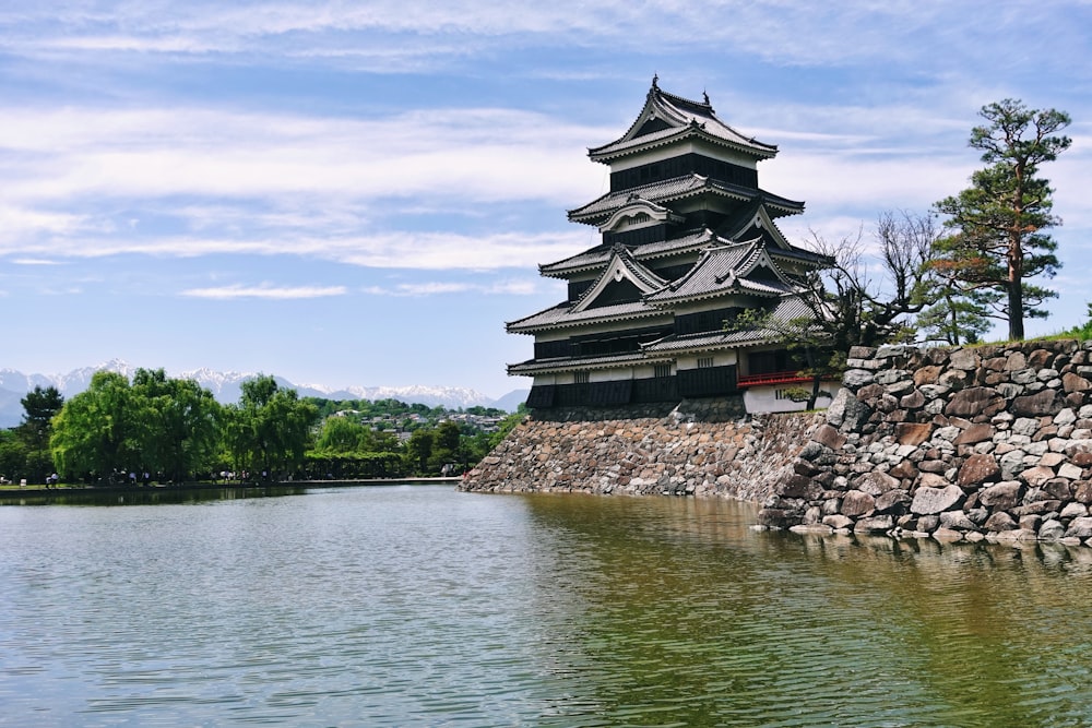 a building on a rock wall by water