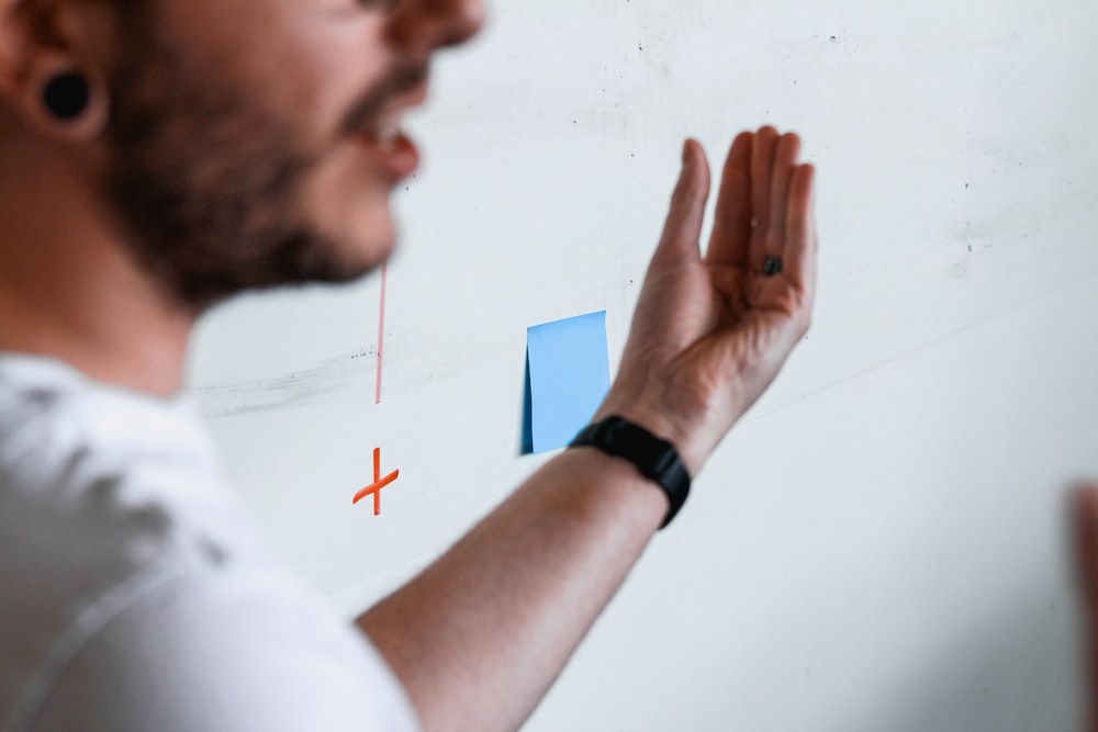 a man drawing a diagram on a white board