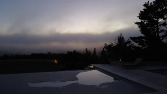 A serene backyard pool at sunset with a family enjoying the water, reflecting warmth and trust.