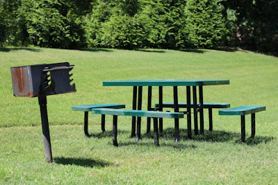 Families enjoying a barbecue under kiosks equipped with churrasqueras and picnic tables