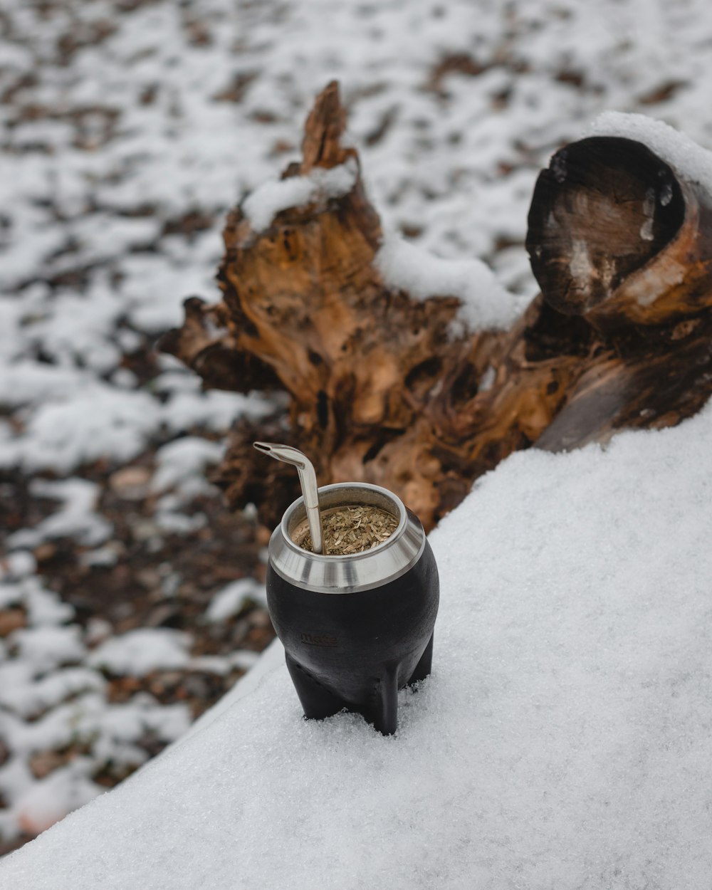 a cup of liquid on a snowy ground