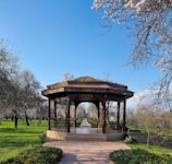 Handcrafted wooden gazebo surrounded by blooming garden flowers.