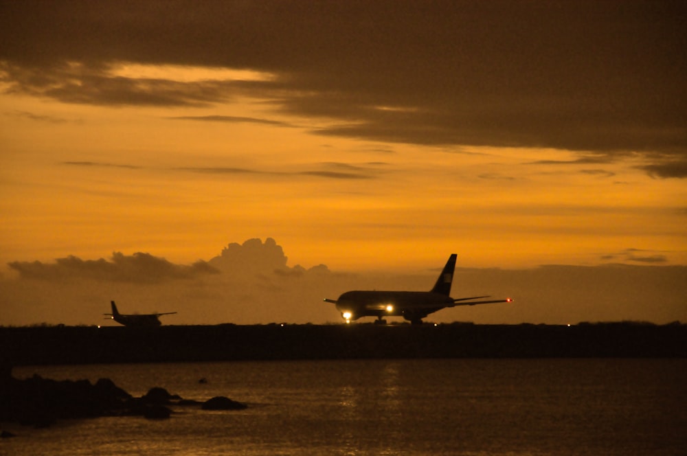 a couple of airplanes at sunset