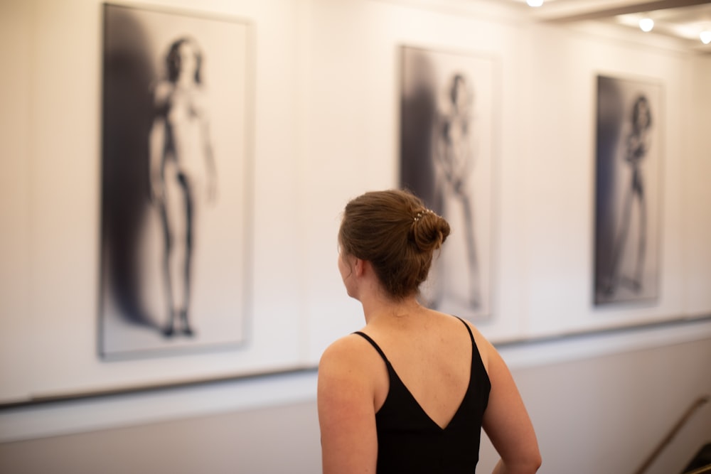 a woman looking at art on the wall