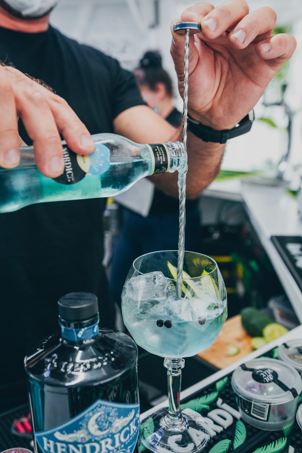 a person pouring a drink into a glass