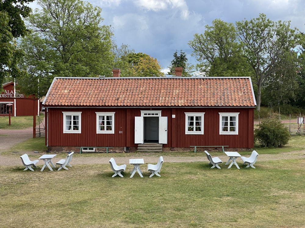 a red barn with white chairs in front of it