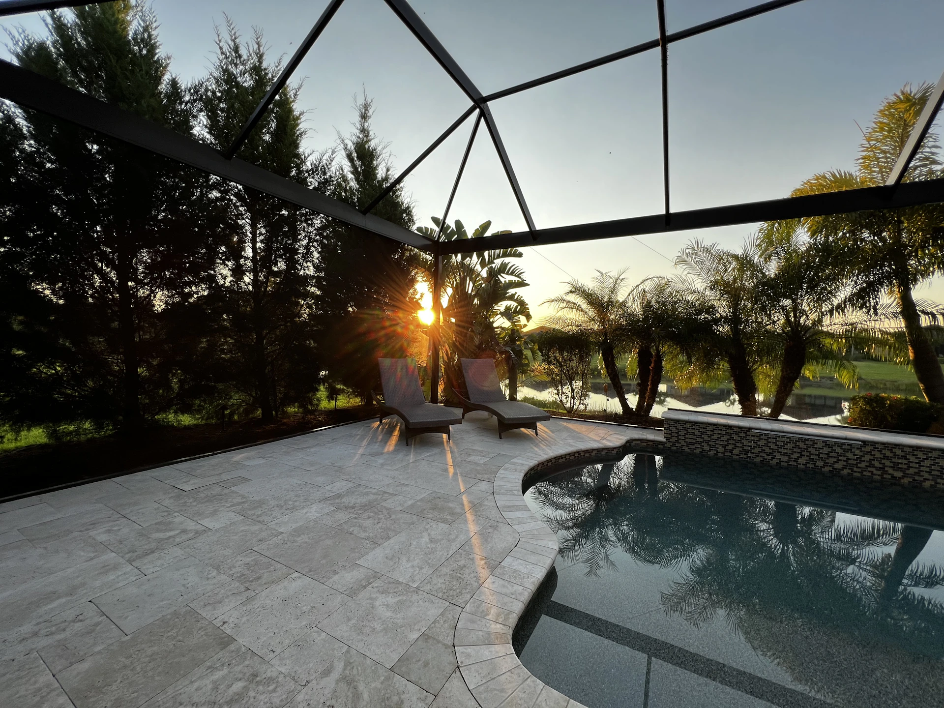 a pool with a hammock over it and trees around it