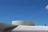 Wide shot of a minimalist rooftop with sharp lines and premium waterproof coating reflecting sunlight.