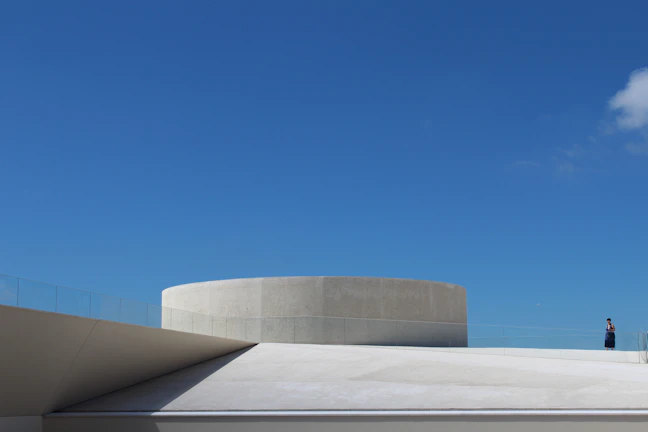Wide shot of a minimalist rooftop with sharp lines and premium waterproof coating reflecting sunlight.