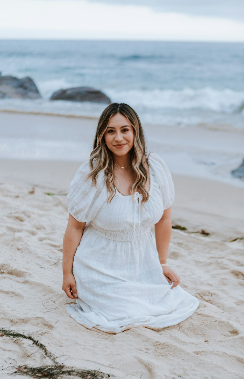 a person in a white dress on a beach