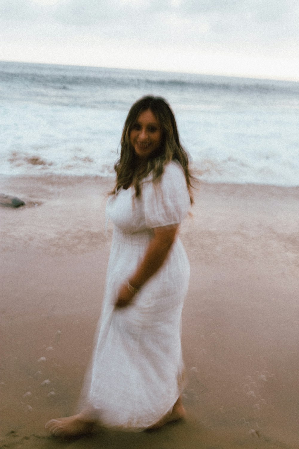 a person in a white dress on a beach