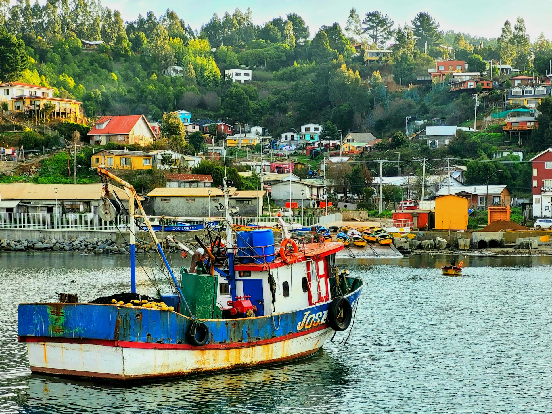 Colorful fishing boats resting on the shore of the peaceful fishing village, framed by lush greenery.