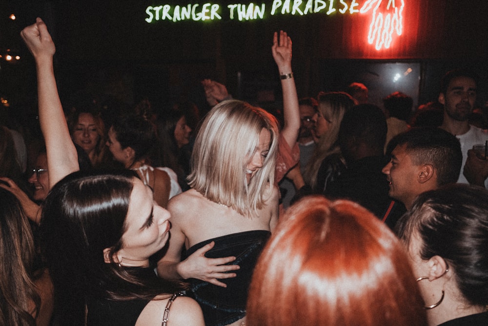 a woman with her arms raised in a crowd of people