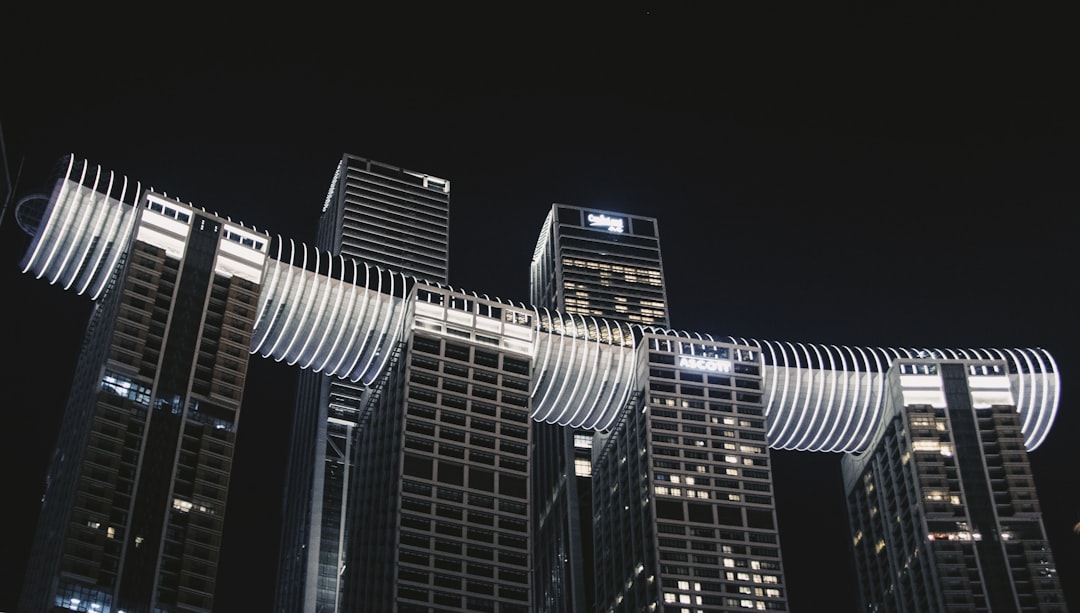 a group of tall buildings, Raffles City at Night