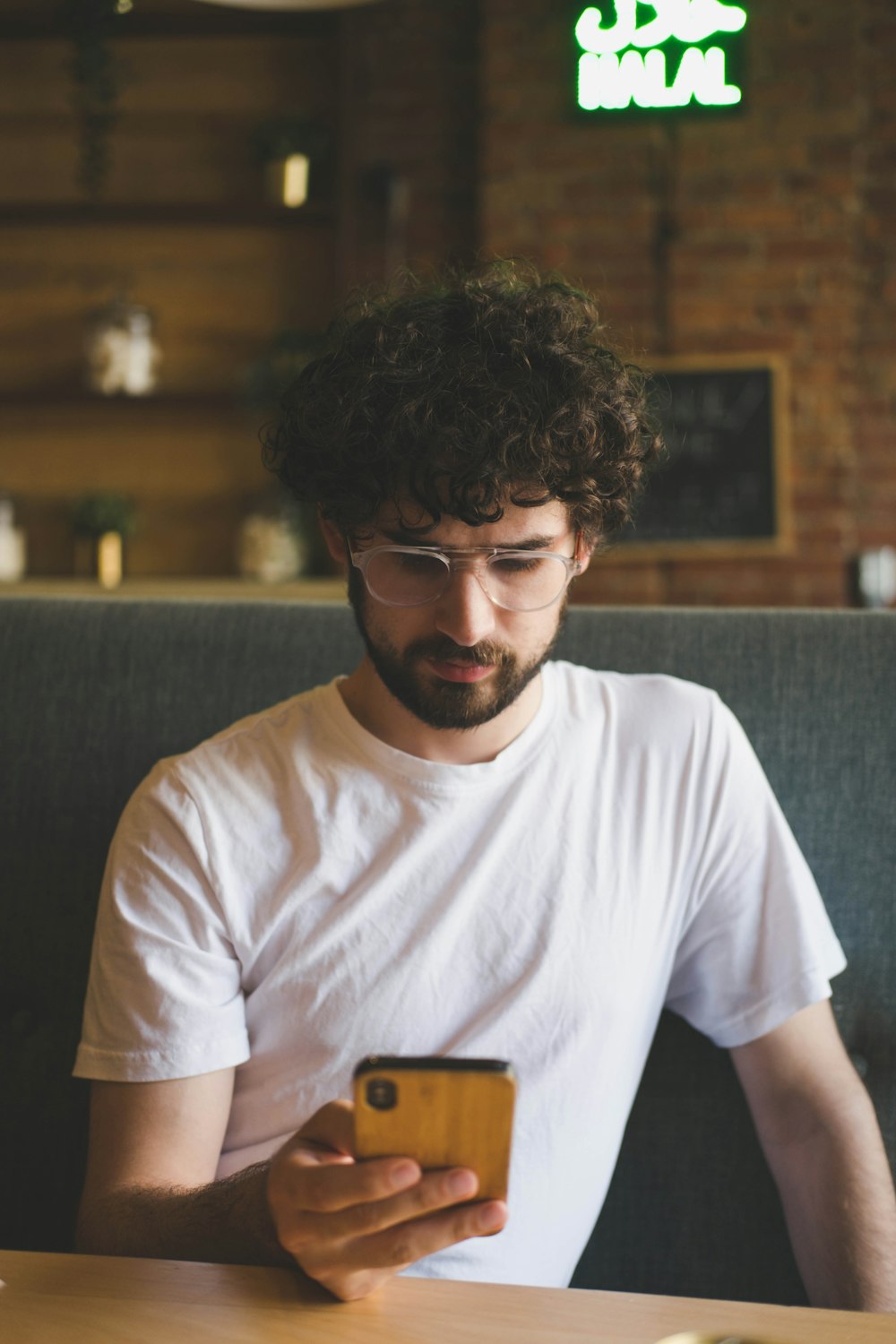 a man with curly hair holding a phone