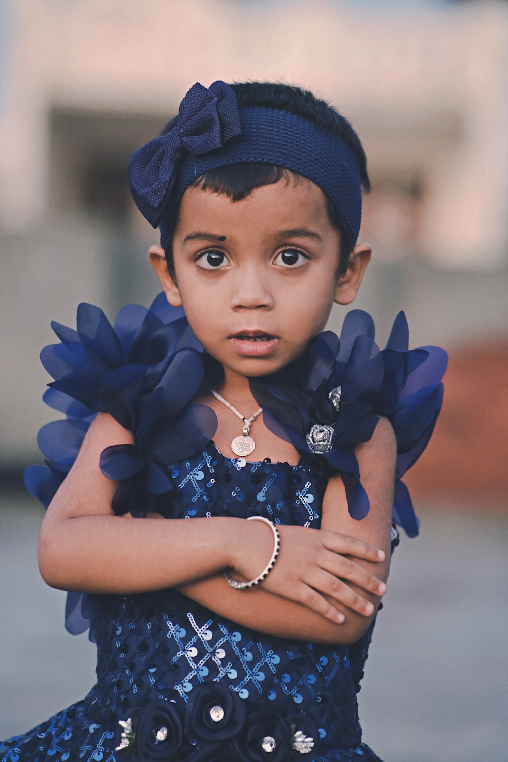 a young girl wearing a blue dress and a blue hat