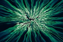 A dynamic and abstract composition featuring flowing, organic shapes radiating from a central point. The intricate design creates a sense of movement and energy, reminiscent of ocean currents or strands of flowing hair.