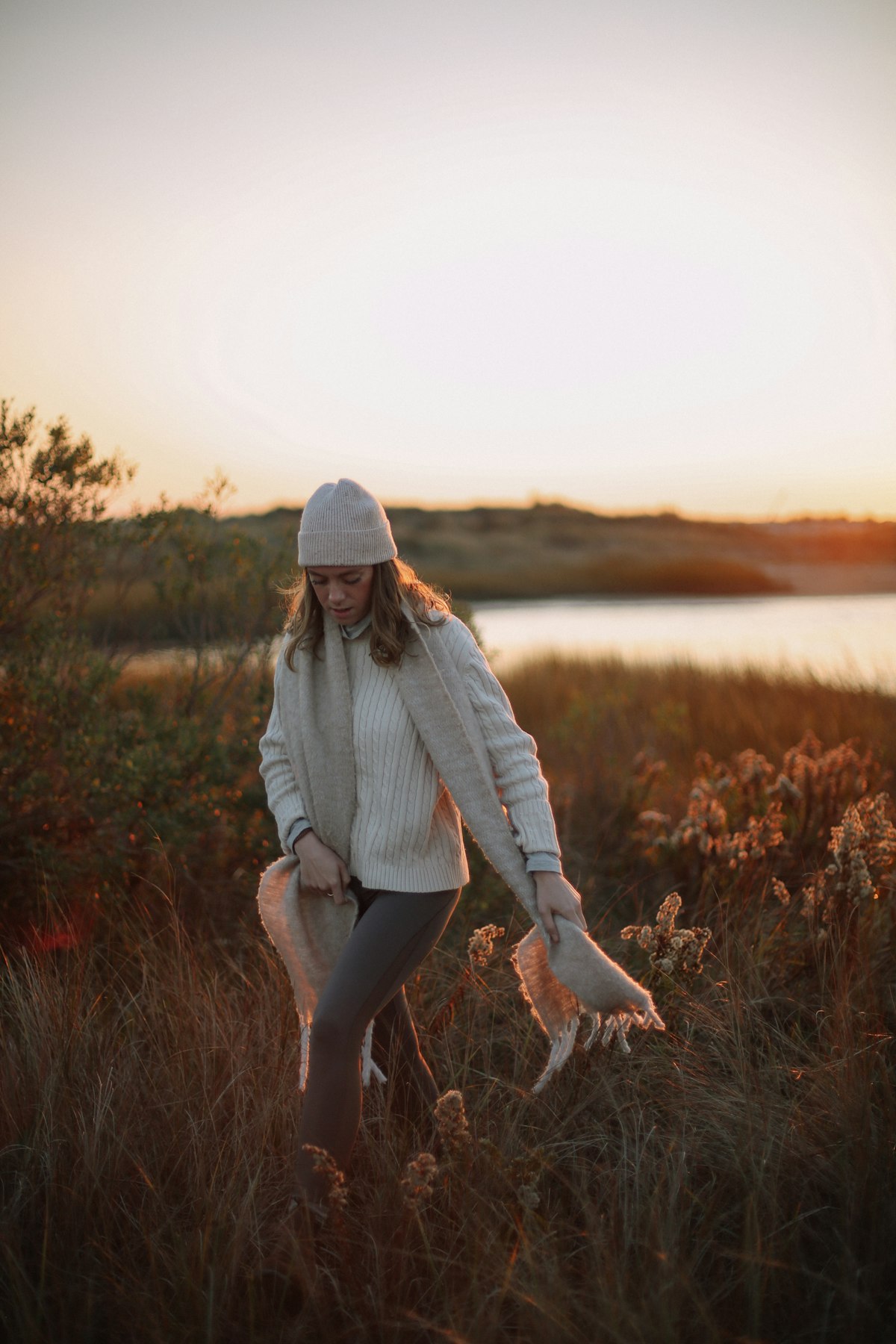 Fashion model captured in soft golden hour light in an open field