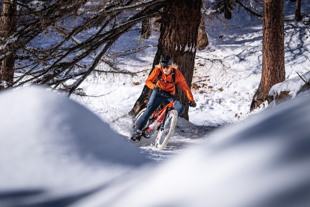 a person riding a bike in the snow