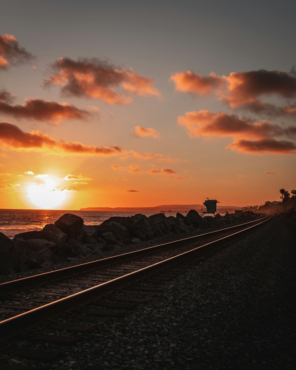 a sunset over a rocky beach