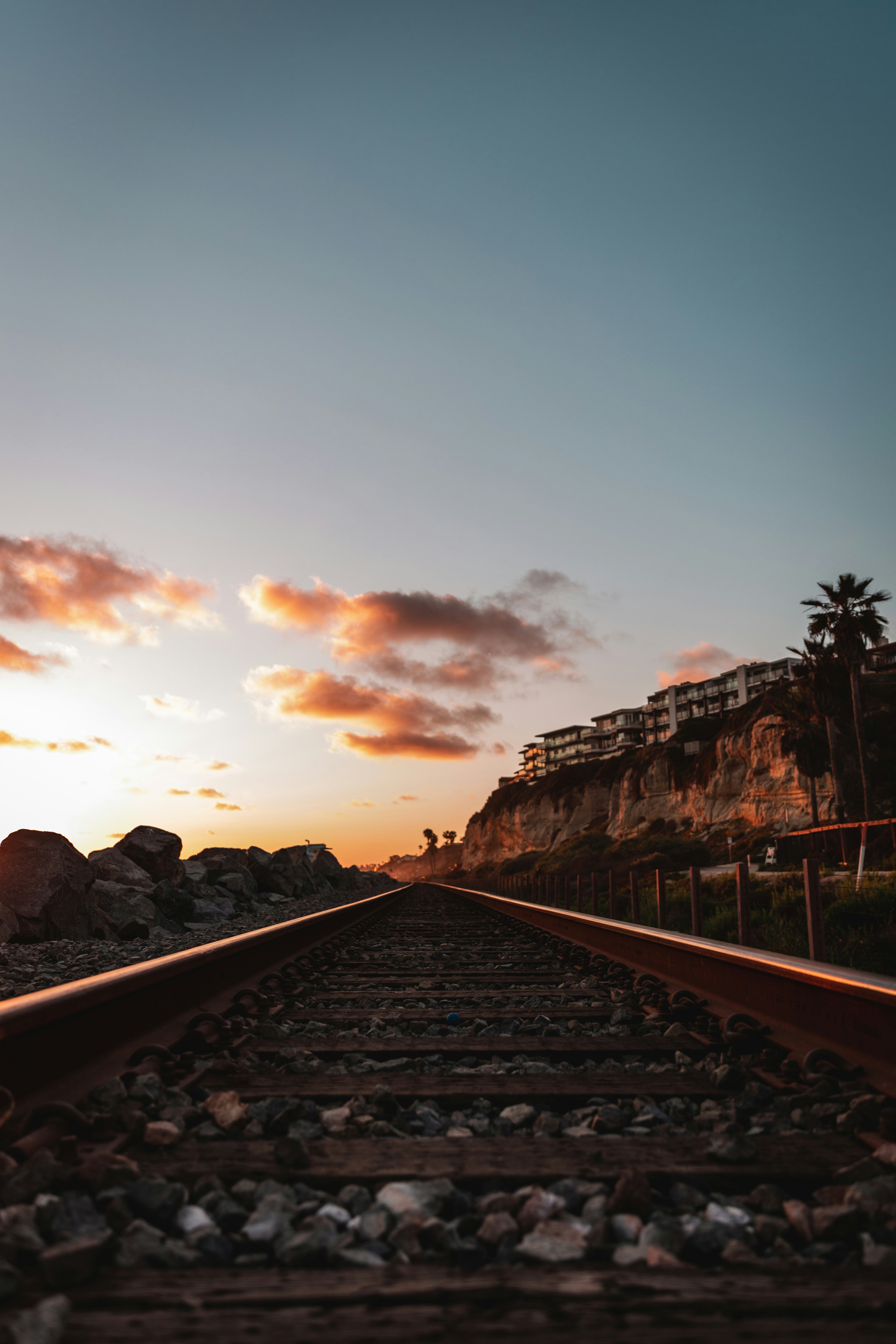 Train tracks with a building in the background photo – Free Sunset ...