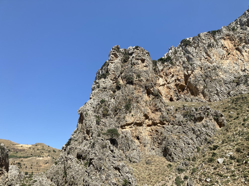 a rocky mountain with a blue sky