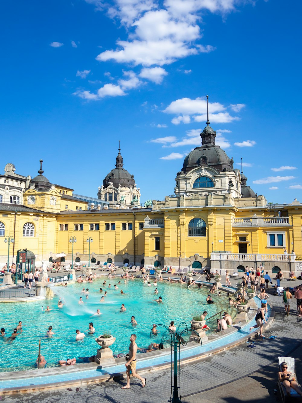 a large pool with people in it and a building in the background