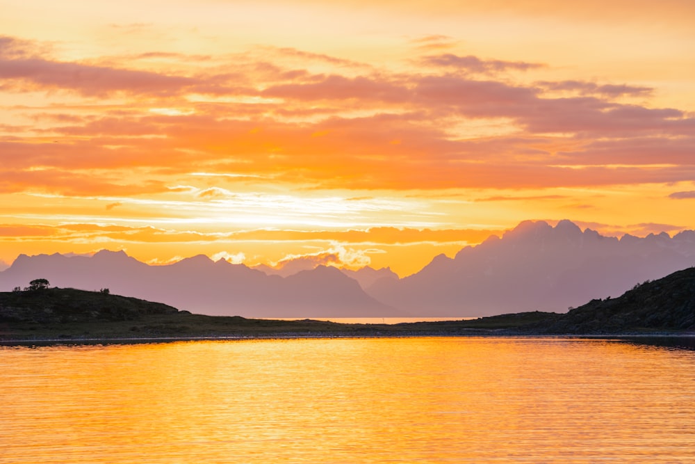 a body of water with mountains in the background